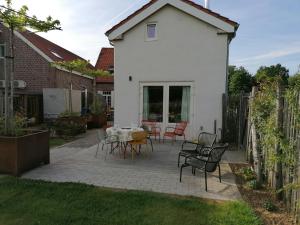 a patio with a table and chairs in a yard at B&B Leybeeckhof in Holsbeek
