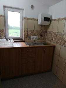 a kitchen with a sink and a window at Domek pod Zatorem in Ryczów