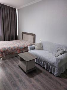 ein Schlafzimmer mit einem Bett, einem Sofa und einem Tisch in der Unterkunft Кобулети Residence двухспални Апартаменты Gio in Kobuleti