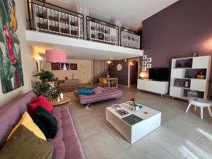 ZEFIA HOME في كاتانيا: غرفة معيشة مع أريكة أرجوانية وطاولة