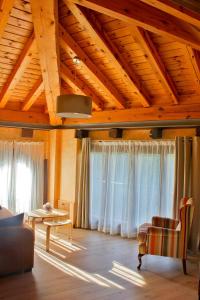 una sala de estar con cortinas blancas y techo de madera. en La Casa del Abad, en Anguiano