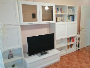 a white entertainment center with a flat screen tv at Il Gioiello Nel Parco - Sanremo Apartments in Sanremo