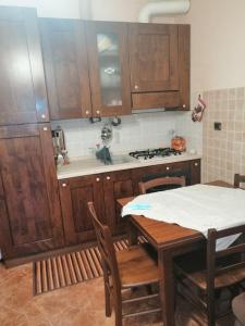 聖雷莫的住宿－Il Gioiello Nel Parco - Sanremo Apartments，厨房配有木制橱柜和桌椅