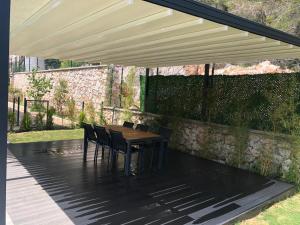 eine Terrasse mit einem Tisch und Stühlen unter einem Baldachin in der Unterkunft Silyan Villas in Antalya
