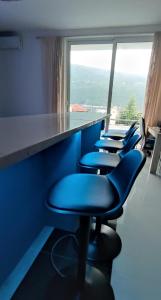 eine Reihe blauer Stühle in einem Raum mit einem Fenster in der Unterkunft Sunrise Djenovici in Ðenovići + 10 Fotos