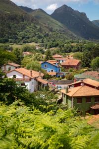 a small village with houses and mountains in the background at Hotel La Casona de Nueva in Nueva de Llanes +68 photos