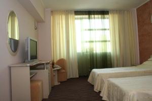 a hotel room with two beds and a television at Hotel Zytto by Razvan Rat in Slatina