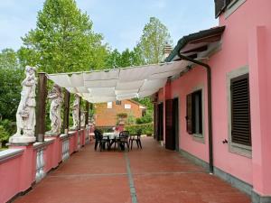 a patio with tables and chairs on a pink building at Pirro & Sharon House in Pianore