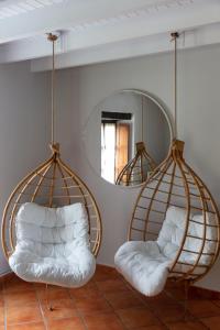 two swinging chairs in a room with a mirror at Hotel La Casona de Nueva in Nueva de Llanes