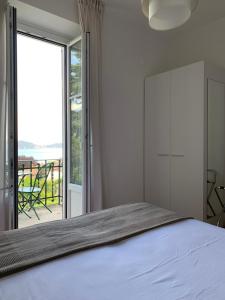 a bedroom with a bed and a large window at Hotel Loveno in Menaggio