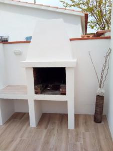 una chimenea blanca en una sala de estar con mesa en Delightful Villa close to the beach, en L'Escala
