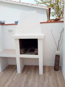 a white fireplace in a living room with a table at Delightful Villa close to the beach in L'Escala