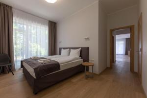 a bedroom with a bed and a large window at Oasis Apartments in Jūrmala