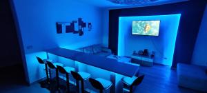 ein blauer Raum mit einer Bar mit Stühlen darin in der Unterkunft Sunrise Djenovici in Ðenovići