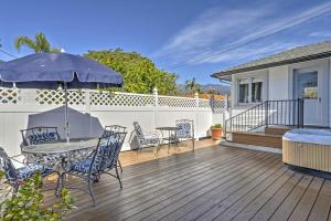 a deck with a table and chairs and an umbrella at Carpinteria Apt with Hot Tub - 10 Min Walk to Beach! in Carpinteria