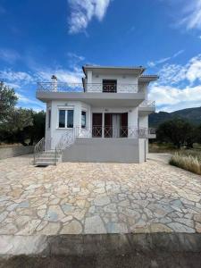 duży biały dom z dużym kamiennym podjazdem w obiekcie Nafpaktos Shingle Villa w mieście Nafpaktos