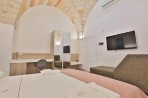 1 dormitorio con 2 camas y TV de pantalla plana en B&B Villa Gentile, en Galatina