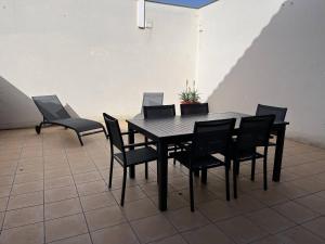 - czarny stół i krzesła w pokoju w obiekcie Maison rénovée 4 pièces au cœur de St Pierre d'Oléron avec terrasse, proche commerces, 6 couchages - FR-1-246A-137 w mieście Saint-Pierre-dʼOléron