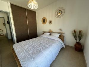 sypialnia z białym łóżkiem i zegarem na ścianie w obiekcie Maison rénovée 4 pièces au cœur de St Pierre d'Oléron avec terrasse, proche commerces, 6 couchages - FR-1-246A-137 w mieście Saint-Pierre-dʼOléron