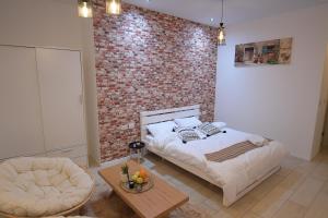 ein Schlafzimmer mit einem Bett und einer Ziegelwand in der Unterkunft White view in Mas'ada