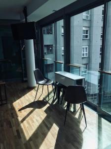 a table and chairs in a room with a large window at Apartamento Rosario 2 in Vigo