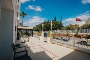 un balcon d'un bâtiment avec un banc et des plantes en pot dans l'établissement Hotel Soussana, à Sousse