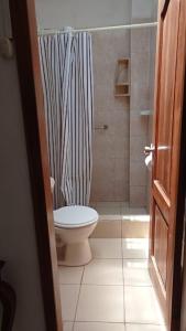 a bathroom with a shower curtain and a toilet at MyBestStay Piedra del Mar in Puerto López