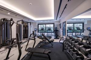 a gym with treadmills and chairs in a room at Tropicana Hotel , Suites & Villas Mykonos in Paradise Beach