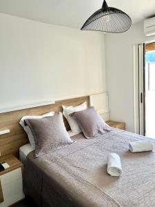 ein Schlafzimmer mit einem großen Bett mit Kissen darauf in der Unterkunft PIEDS DANS L'EAU, TIUCCIA, appartement 2-4 pers in Casaglione