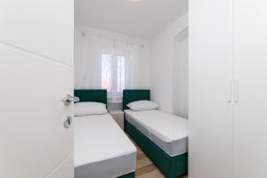 Posteľ alebo postele v izbe v ubytovaní Apartmani Čanaki Supetar