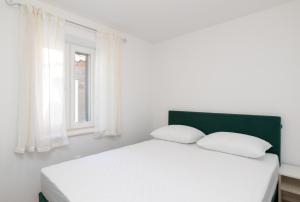 Posteľ alebo postele v izbe v ubytovaní Apartmani Čanaki Supetar