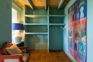 a living room with green walls and a book shelf at Villa Riu Blanc in Benissa