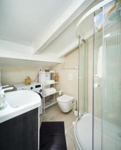 La salle de bains est pourvue de toilettes, d'un lavabo et d'une douche. dans l'établissement Cardo Apartments, à Poreč
