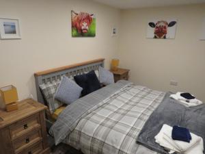a bedroom with a bed and a cow on the wall at The Stables At Eastmoor Farm in Bridlington