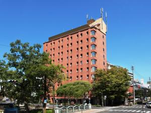 a tall red brick building on a city street at Central Hotel Okayama in Okayama