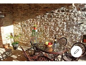 une table et des chaises devant un mur de pierre dans l'établissement Old istrian house,free parking, à Galižana