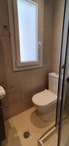 a bathroom with a toilet and a window at Astra Studios Karpathos Island in Karpathos Town