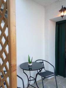 a table and two chairs and a table with a plant on it at Estia κατάλυμα στο Μύρτος in Myrtos