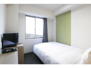 a hotel room with a bed and a flat screen tv at R & B Hotel Kyoto Shijo Kawaramachi - Vacation STAY 40548v in Kyoto