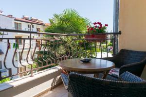 a patio with a table and chairs on a balcony at Guest house Eos in Sozopol