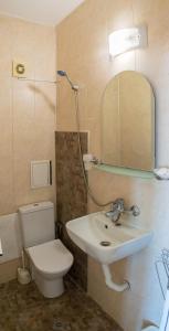 a bathroom with a sink and a toilet and a mirror at Guest house Eos in Sozopol
