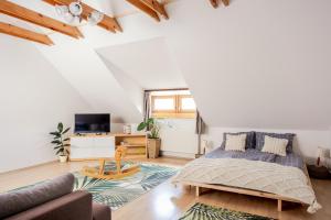 a bedroom with a bed and a living room at Sziklai Apartman in Veszprém