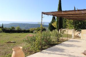 Blick auf einen Garten mit einer Pergola in der Unterkunft Gîte Les Rapières in Gordes