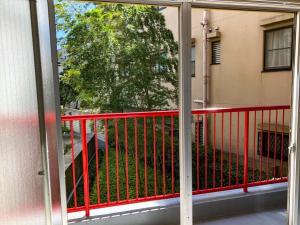 a balcony with a red railing and a tree at Chatley Yoyogi 2 - Vacation STAY 12246 in Tokyo
