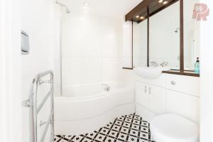 a bathroom with a tub and a toilet and a sink at Two Bedroom Flat By Emporium Property Management Short Lets & Serviced Accommodation Birmingham With Balcony & Close To Central Massplaza in Birmingham +15 photos