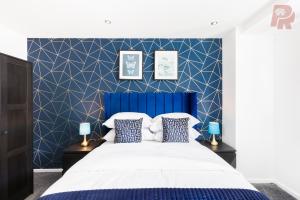 a bedroom with a blue headboard and a white bed at Two Bedroom Flat By Emporium Property Management Short Lets & Serviced Accommodation Birmingham With Balcony & Close To Central Massplaza in Birmingham