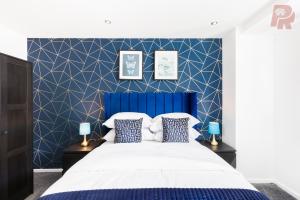 a bedroom with a blue headboard and a white bed at Central Massplaza 2 Bedroom Apartment With Balcony - Hi Floor in Birmingham
