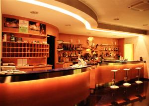 a restaurant with a bar with stools in a room at Hotel Italia in Carmagnola