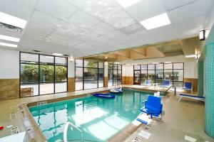 una grande piscina con sedie blu e finestre di Harmony Suites Secaucus Meadowlands a Secaucus