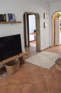 uma sala de estar com uma televisão de ecrã plano e uma mesa em La Estrella - piscina privada em Chiclana de la Frontera